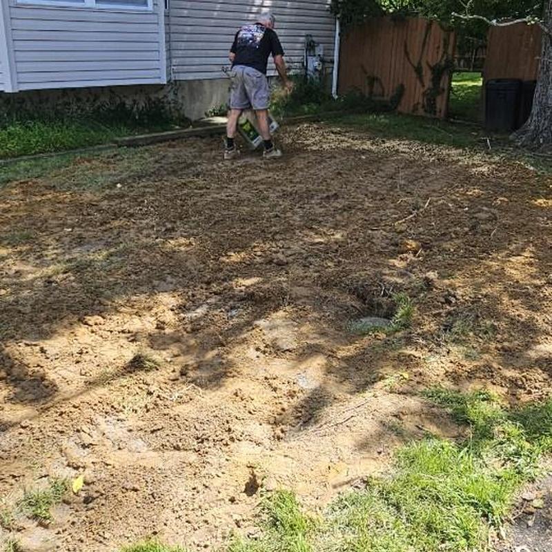 Water service installation site with worker preparing ground