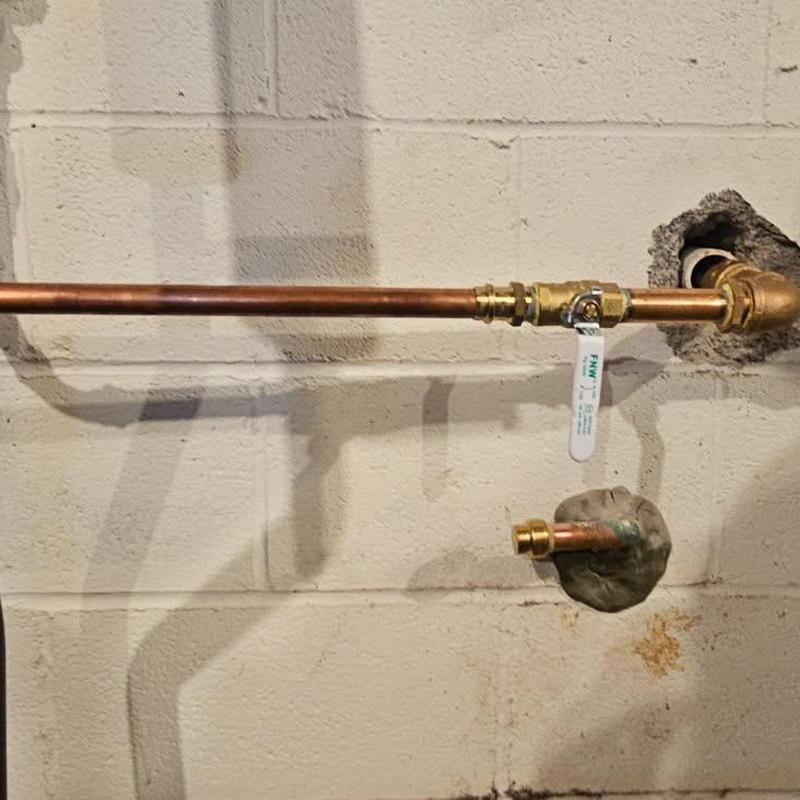 Copper water service pipe with valve in basement wall
