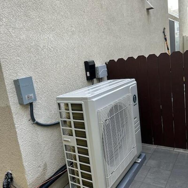 Heat pump unit installed outside near electrical box