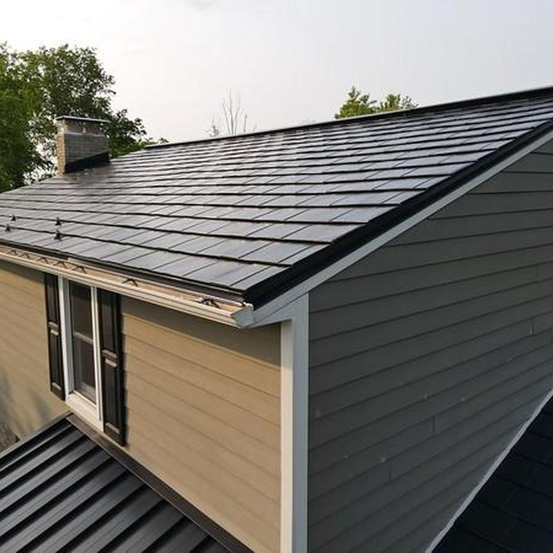 Metal roof with repaired panels after storm damage