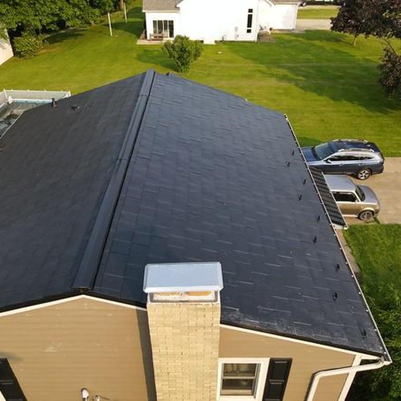 Metal roof with new shingles after storm repair