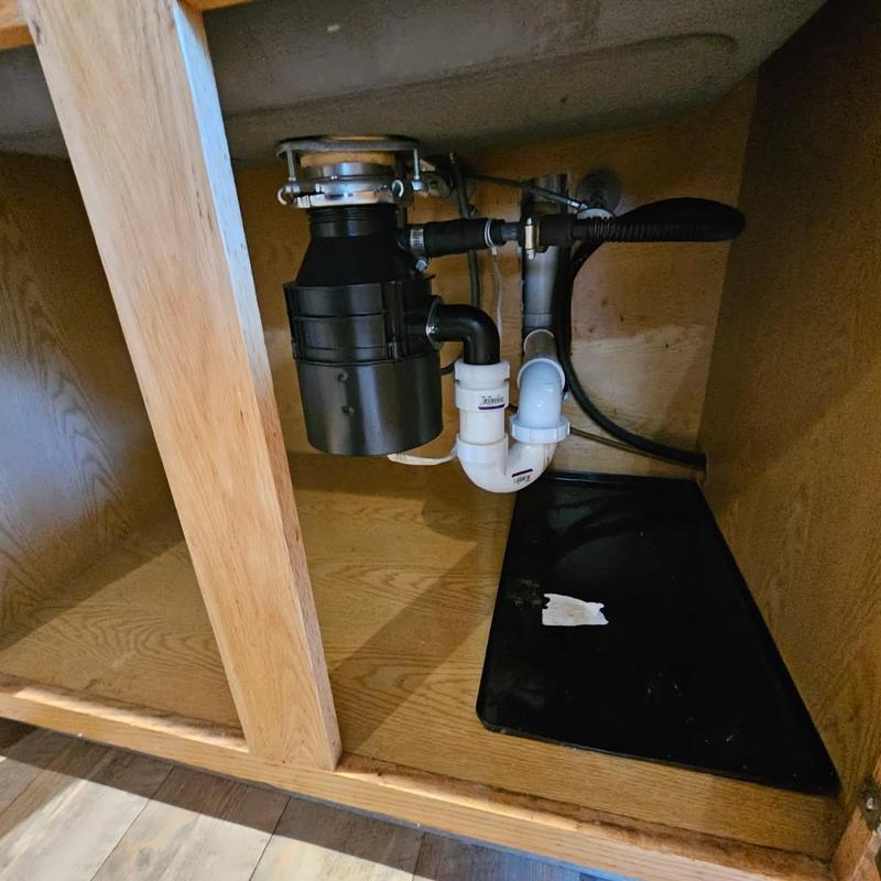 Garbage disposal and plumbing under kitchen sink