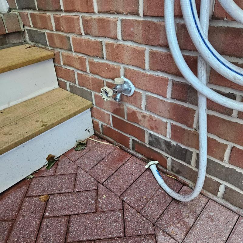 Frost proof hose bib installed on brick wall near steps