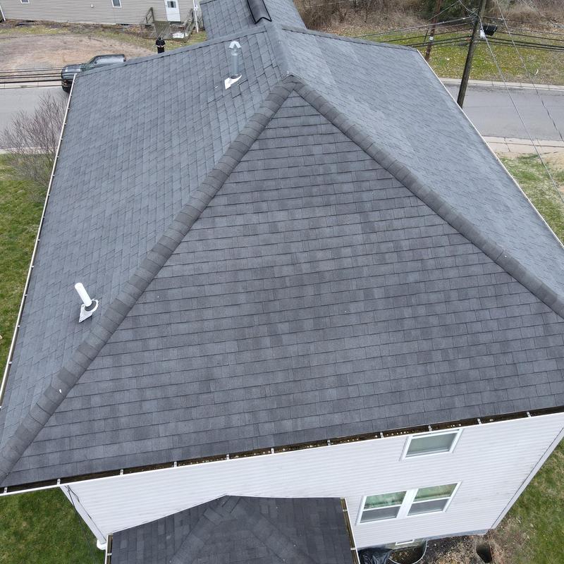 Asphalt shingle roof with ridge vents and exhaust vents
