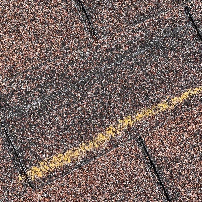 Roof shingles with hail impact markings and damage