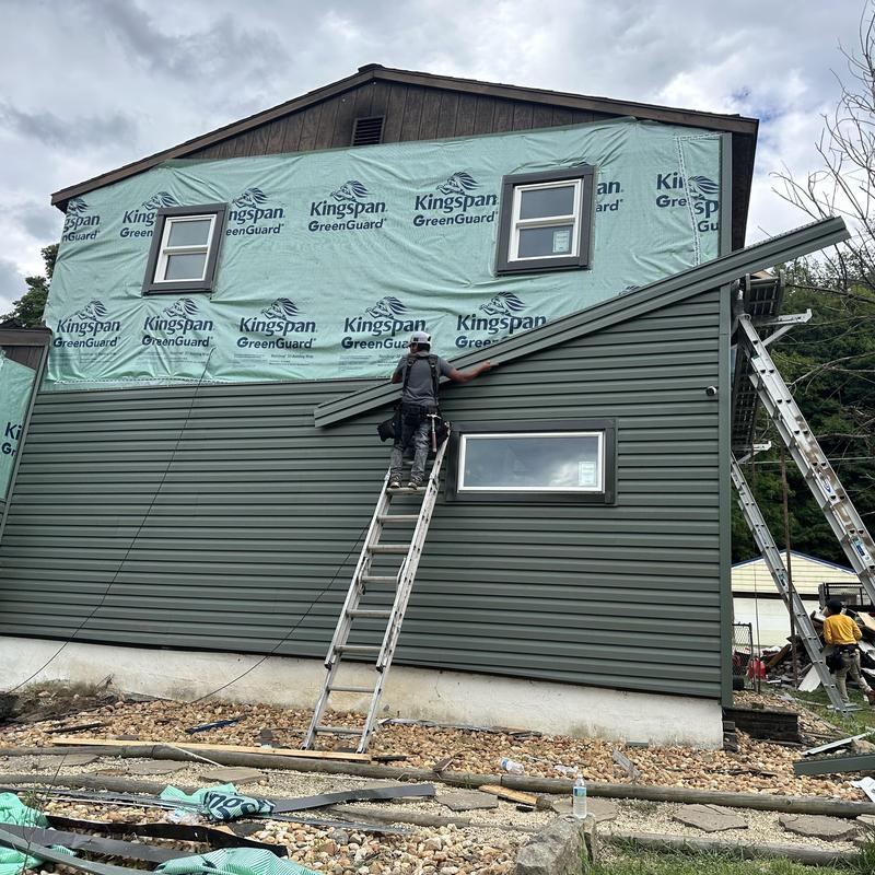 Vinyl siding installation on two-story house exterior