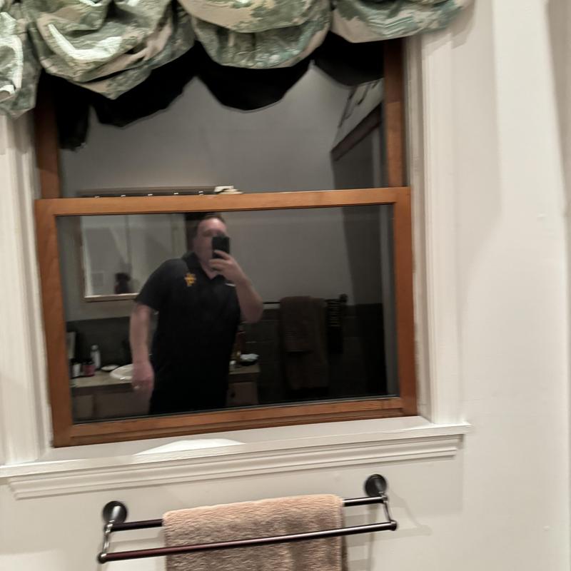 Wood frame bathroom window with green curtain valance