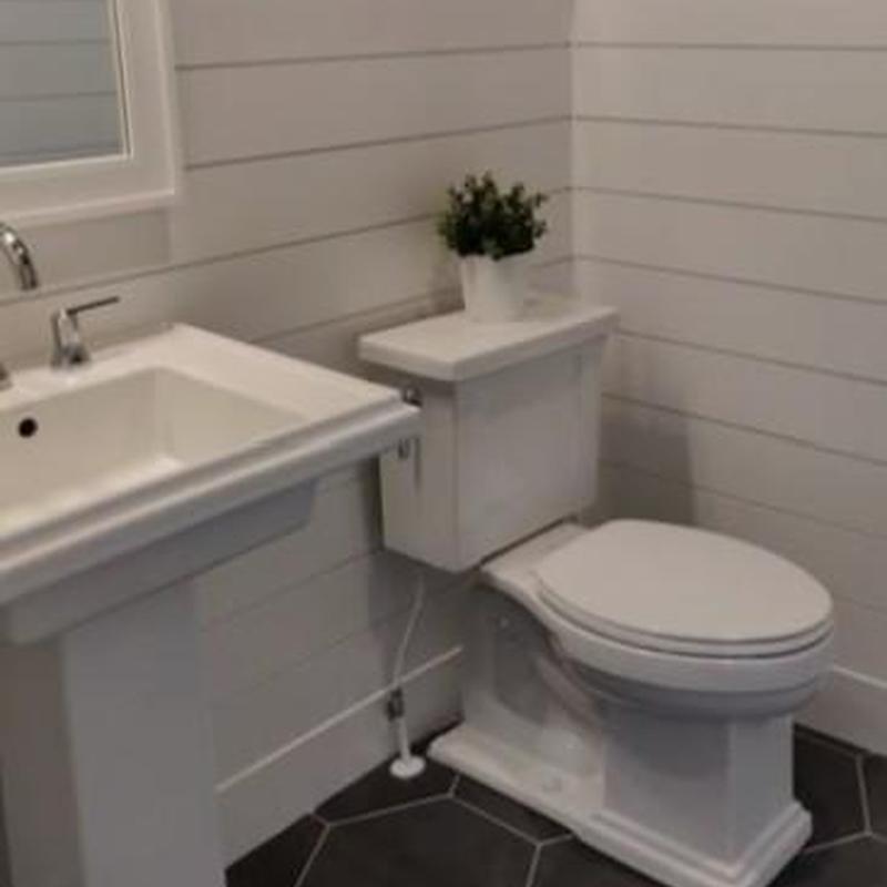 Toilet in upscale powder room with pedestal sink