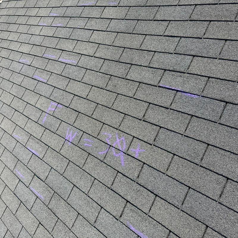Roof shingles with chalk markings for damage inspection