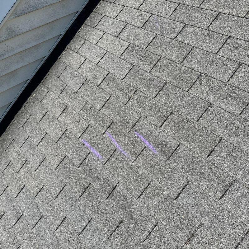 Asphalt roof shingles with storm damage markings