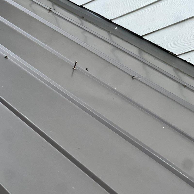 Metal roof panel with loose nails and screws