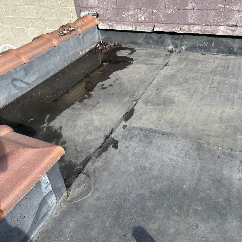 Flat roof with pooling water and damaged flashing