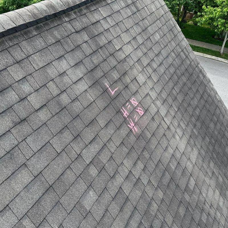 Asphalt shingle roof with chalk storm damage markings