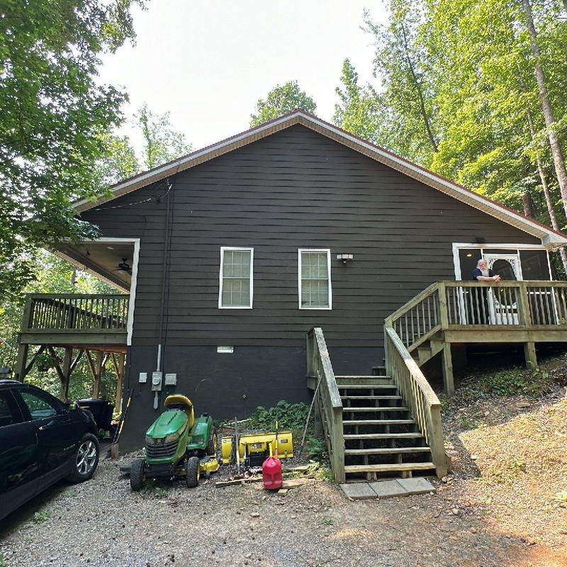 Wooden exterior stairs with railing beside house