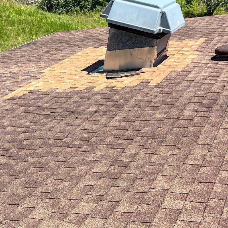 Asphalt shingle roof patch around vent on damaged roof