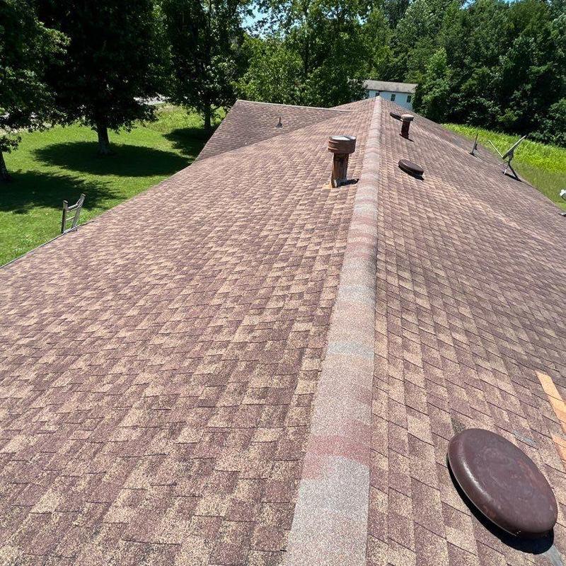 Asphalt shingle roof with vent pipes and ridge cap