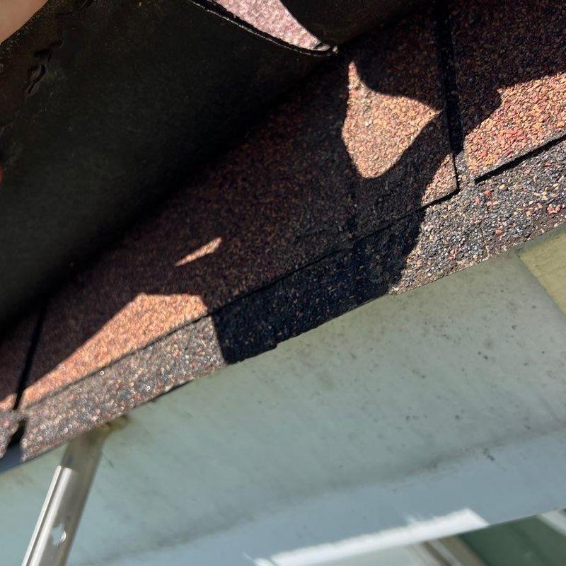 Asphalt roof shingles with visible wear and damage
