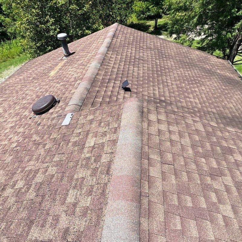 Asphalt shingle roof with visible hail damage and vents