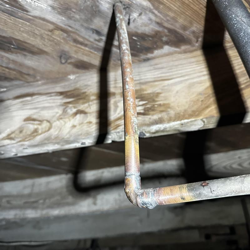 Copper pipe 90° fitting with solder joint under floor joist