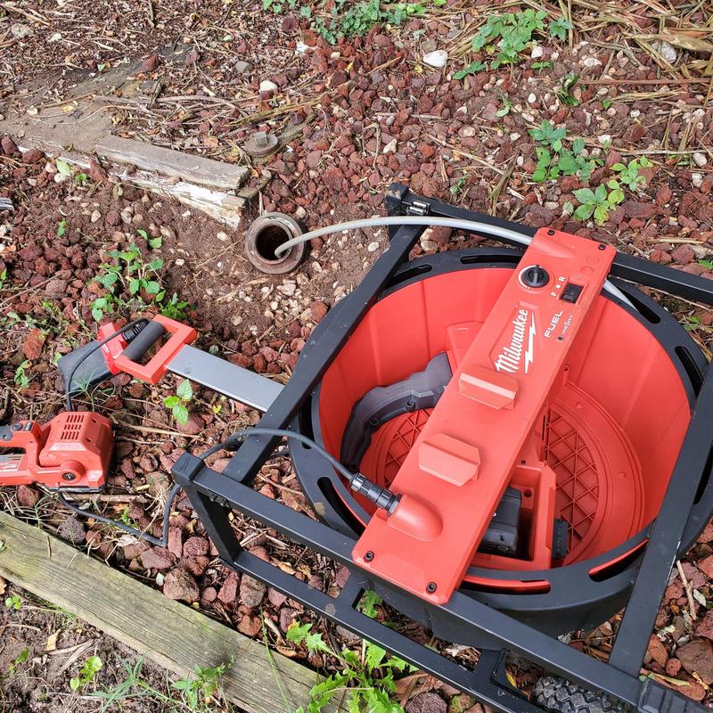 Drain cleaning snake and machine near outdoor drain