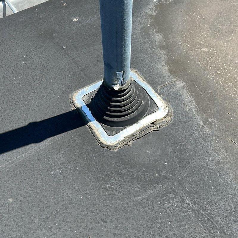Roof vent flashing with weathered sealant on flat roof