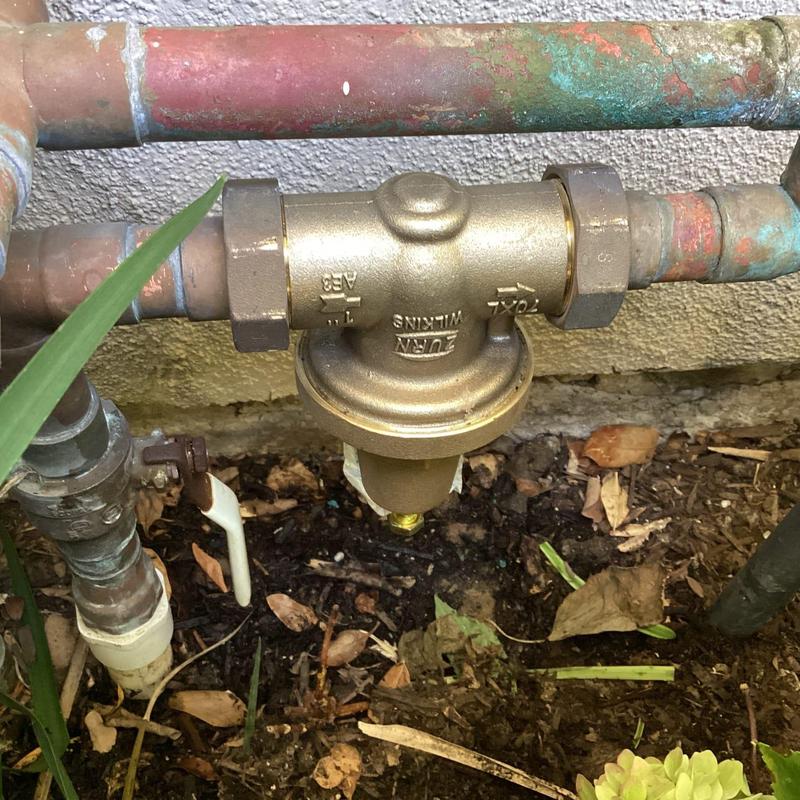 Pressure regulator on outdoor water piping system