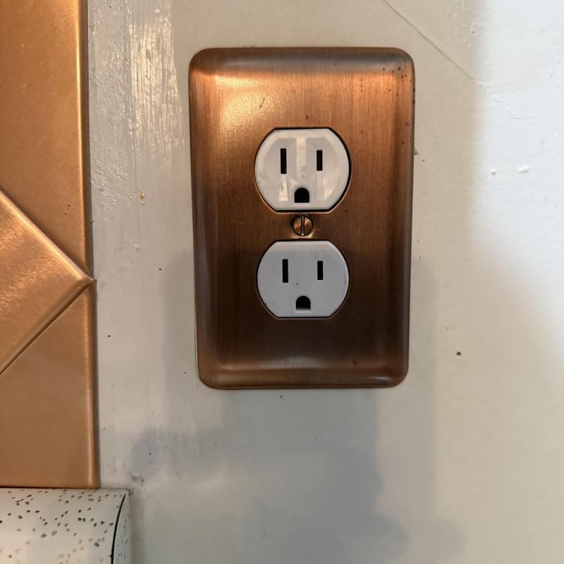 Electrical outlet with new copper cover plate installed