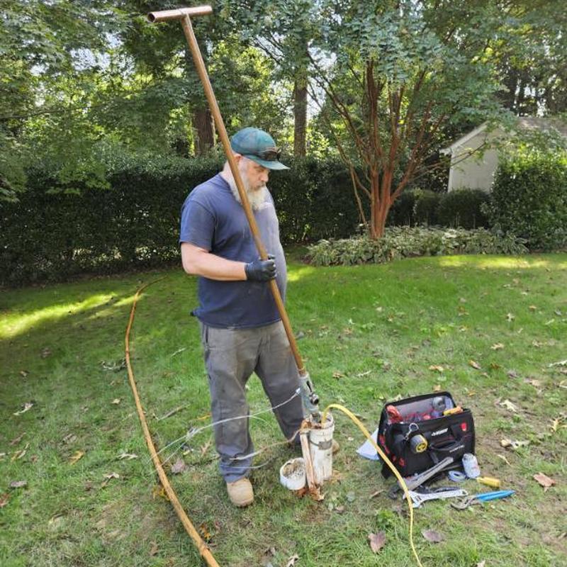 Submersible well pump installation with tools in yard