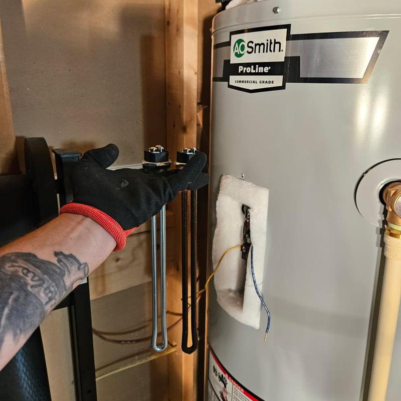 Water heater heating elements held by technician
