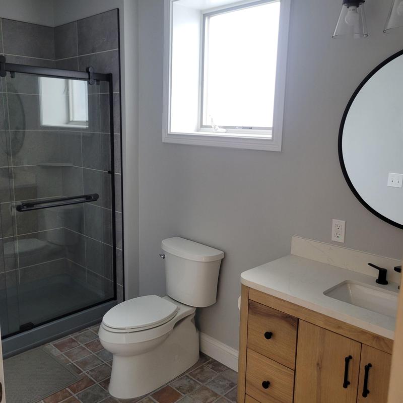 Glass sliding shower doors with tile floor and vanity