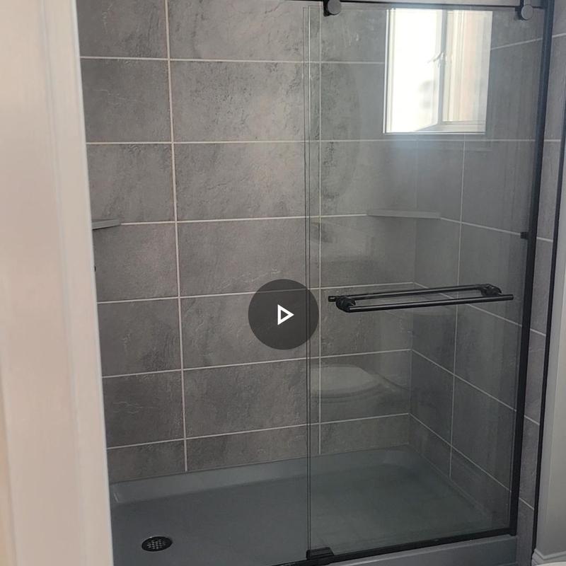 Glass sliding shower door with tiled walls and floor