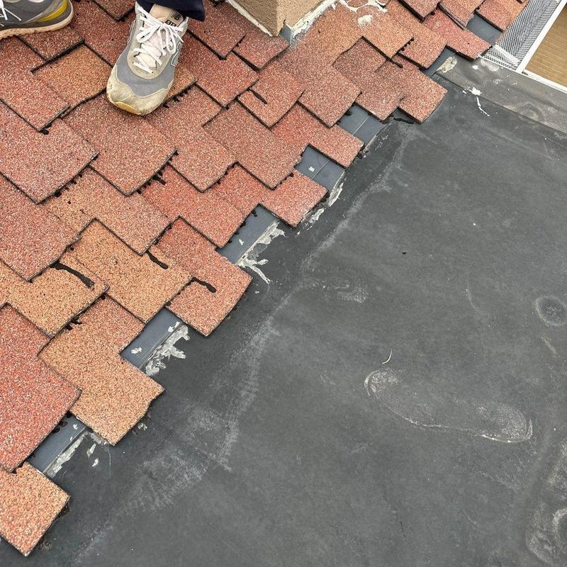 Asphalt shingle roof with missing shingles near flashing