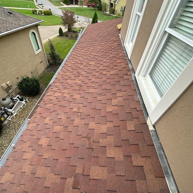 Asphalt shingle roof with storm damage near windows