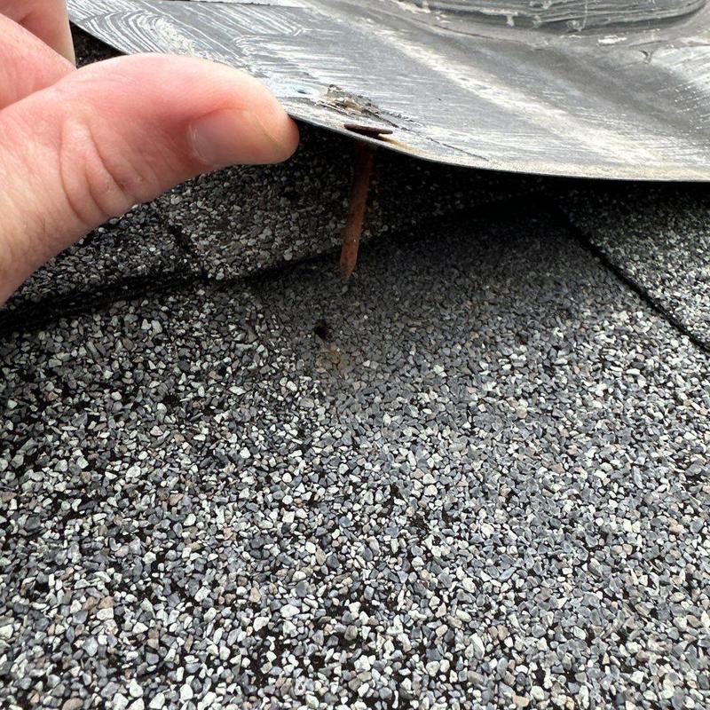 Roof shingles under lifted metal flashing inspection