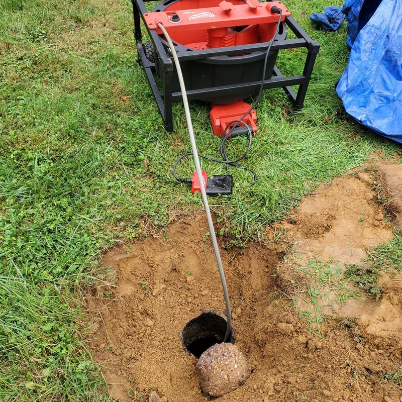 Main drain line clearing with drain snake machine outdoors