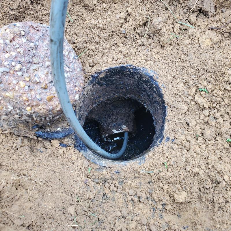 Main septic drain line with snake tool in soil hole