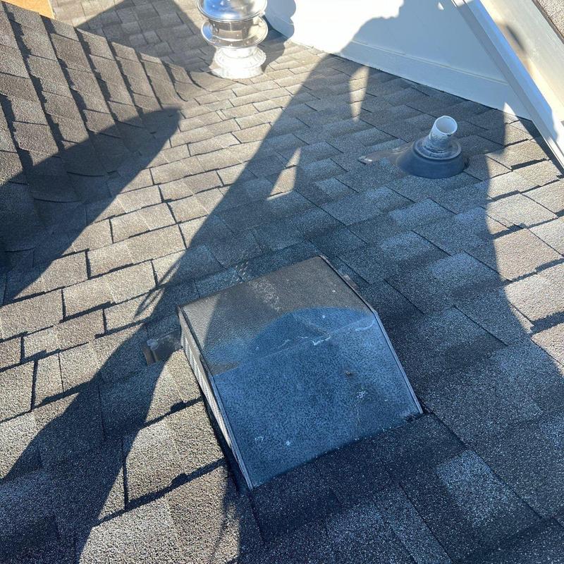 Roof shingles with storm damage near vent pipe