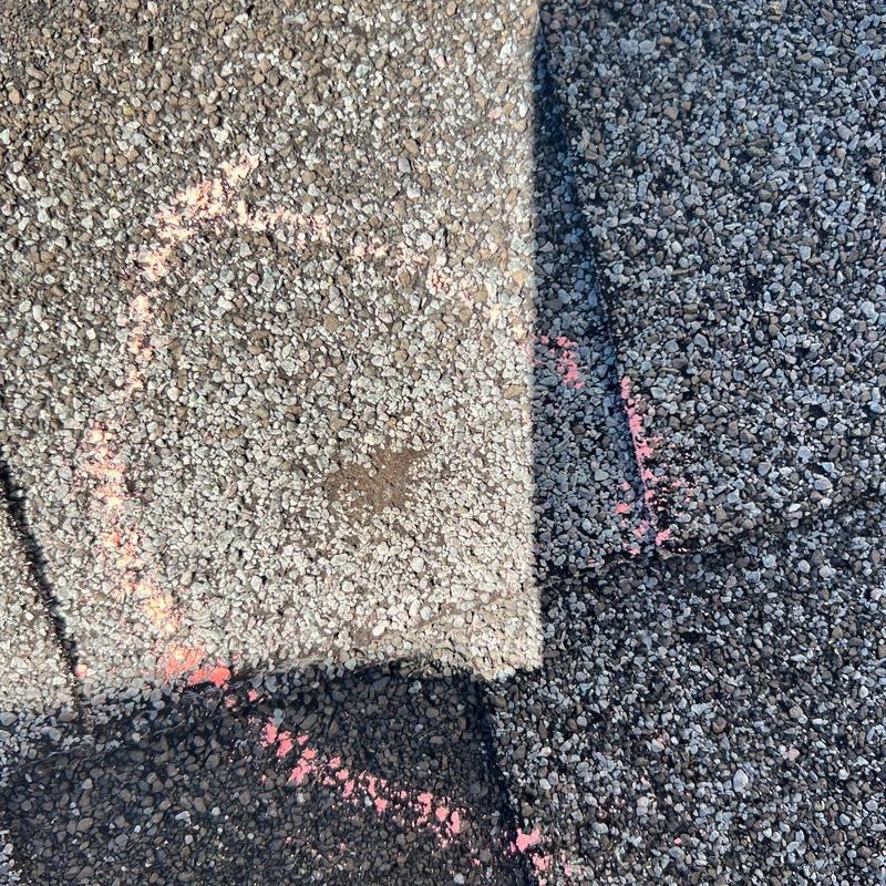 Asphalt roof shingle damage marked for repair