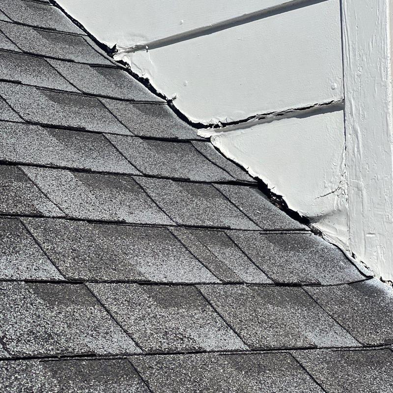 Roof shingles with damaged flashing and sealant gaps
