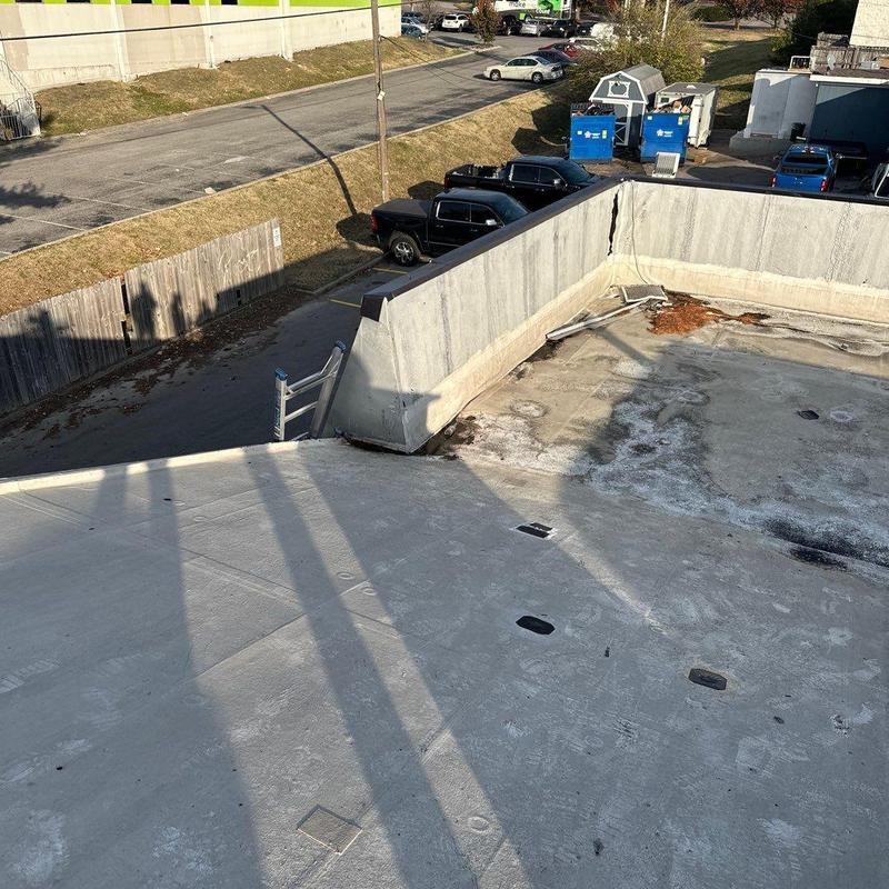 Commercial flat roof with storm damage and wall crack
