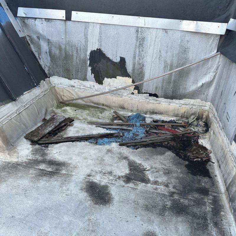 Commercial flat roof with damaged debris and mold buildup