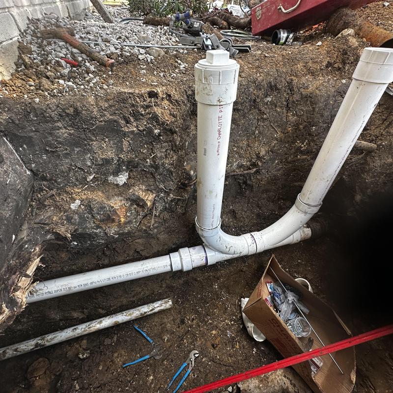 Schedule 40 PVC sewer pipe with riser clamps in trench
