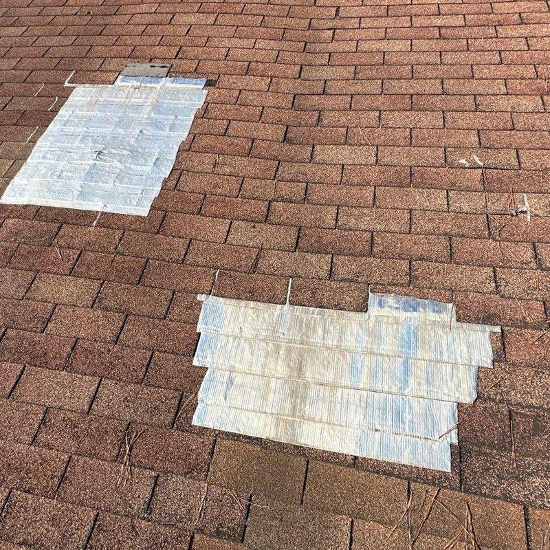 Storm-damaged asphalt shingles with repair patches