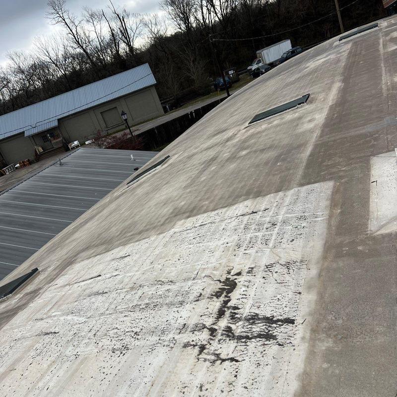 Flat commercial roof with hail and wind damage marks