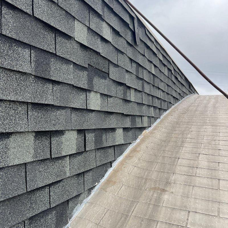Asphalt shingle roof with hail and wind damage marks