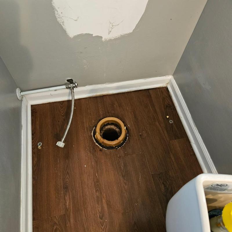 Toilet flange and water supply line in bathroom corner