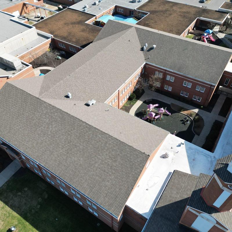 Asphalt shingle church roof with hail and wind damage
