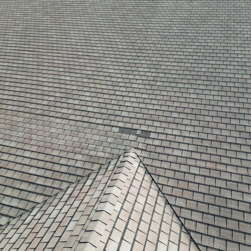 Asphalt shingle roof with hail damage and wind displacement
