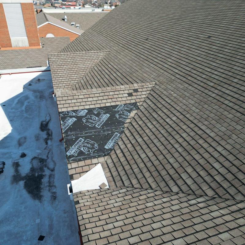 Asphalt shingle roof with exposed underlayment section