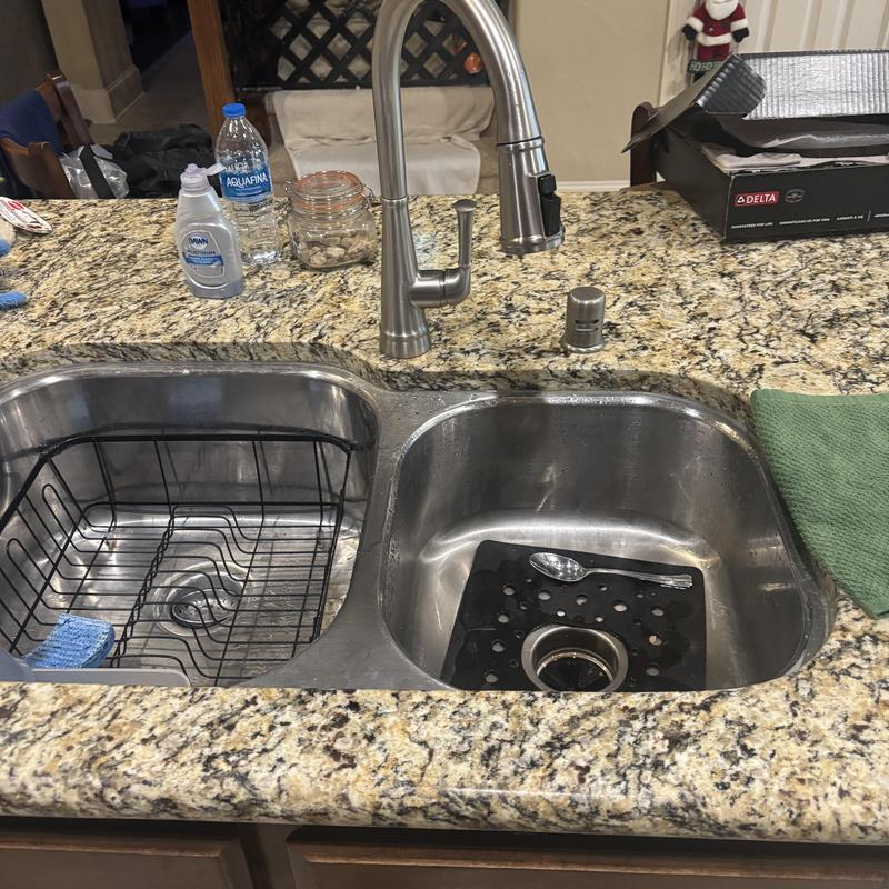Kitchen sink faucet and drainage installation on granite counter